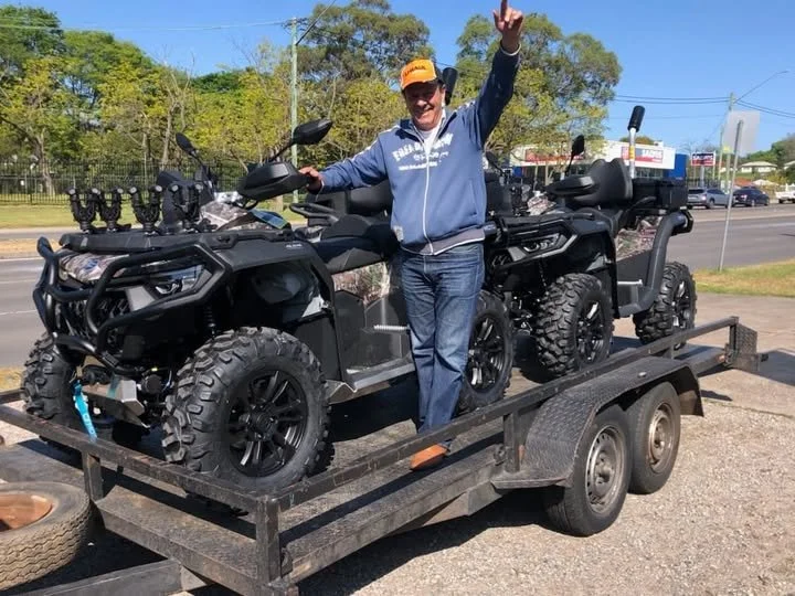 Customer with delivered ATVs on a trailer